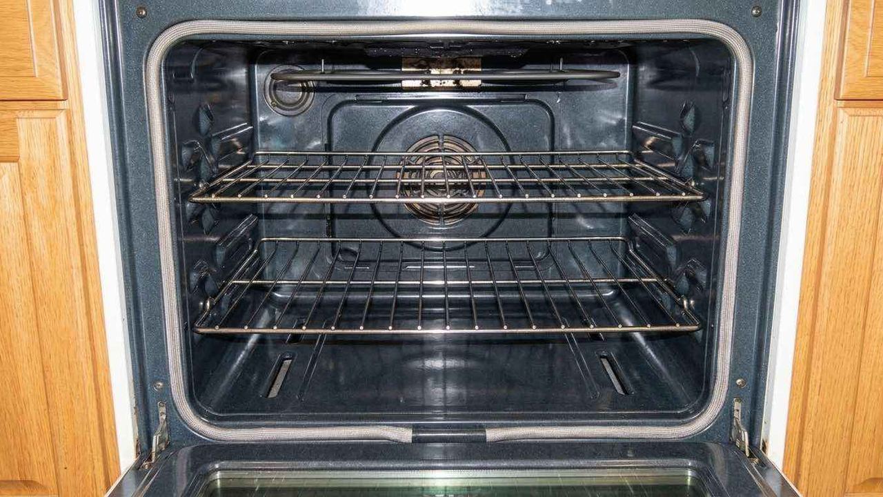 The same oven interior after a deep clean, enamel and racks back to bare metal